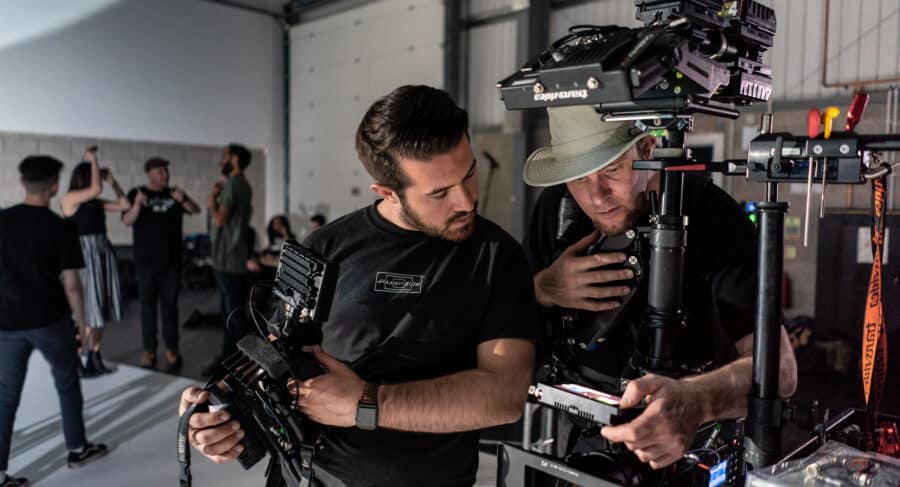two filmmakers looking at camera equipment